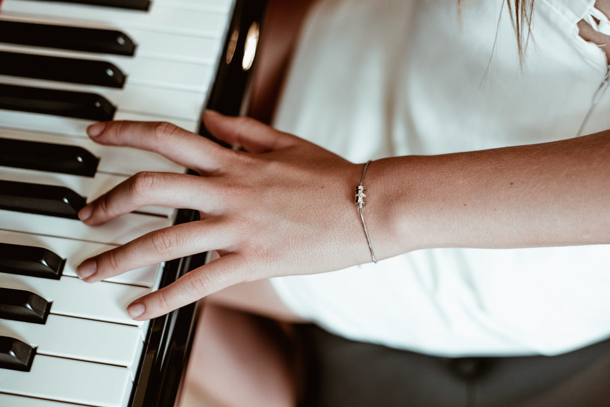 Lock to Heaven bracelet on a wrist at a piano