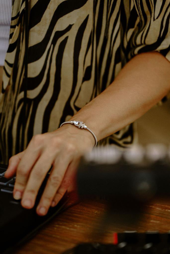 Black and gold-tone VIBES bracelets worn with a white shirt